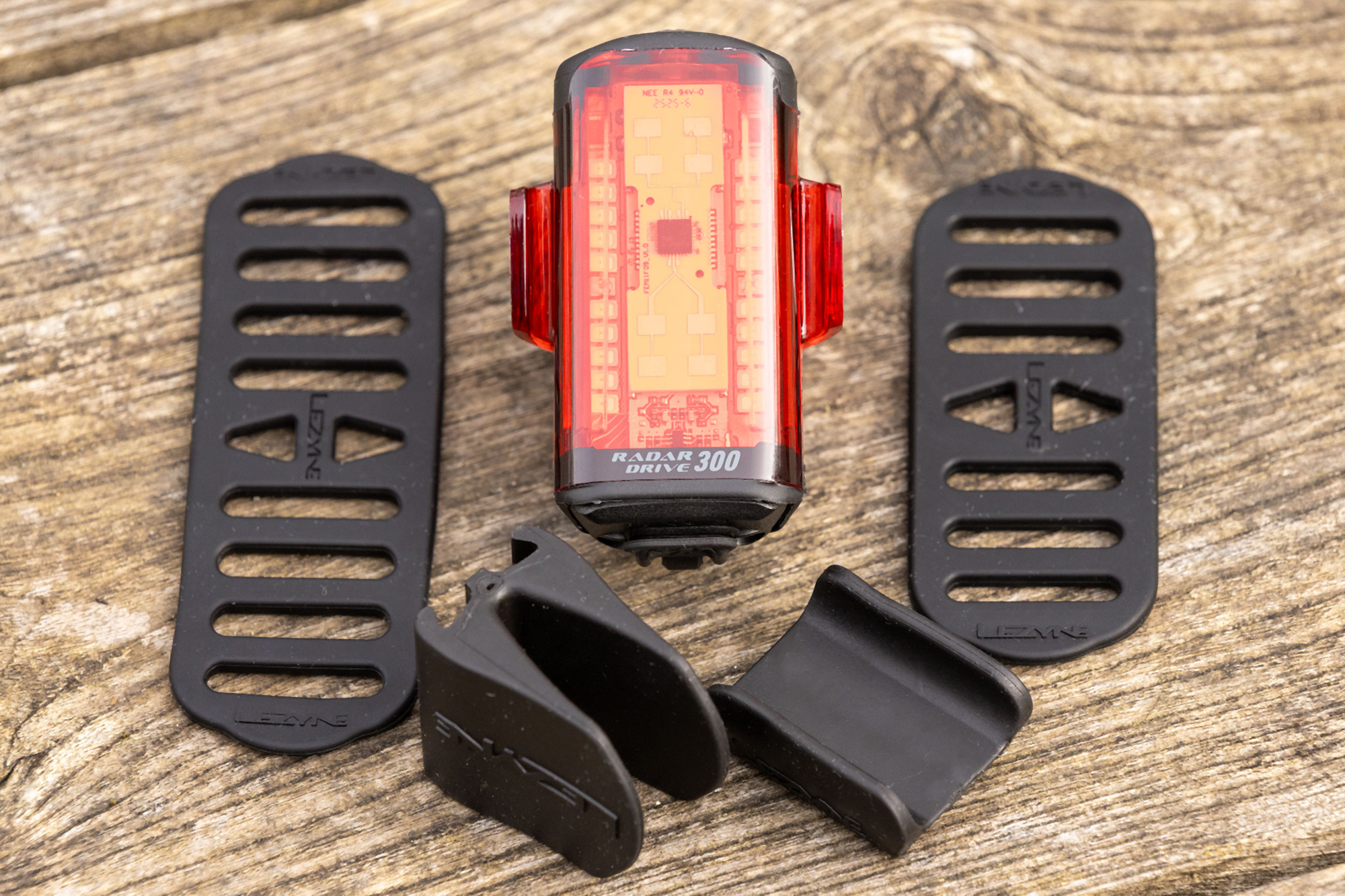 Lezyne Radar Drive Rear pictured off-bike, on wooden table, with straps and rubber seatpost shims