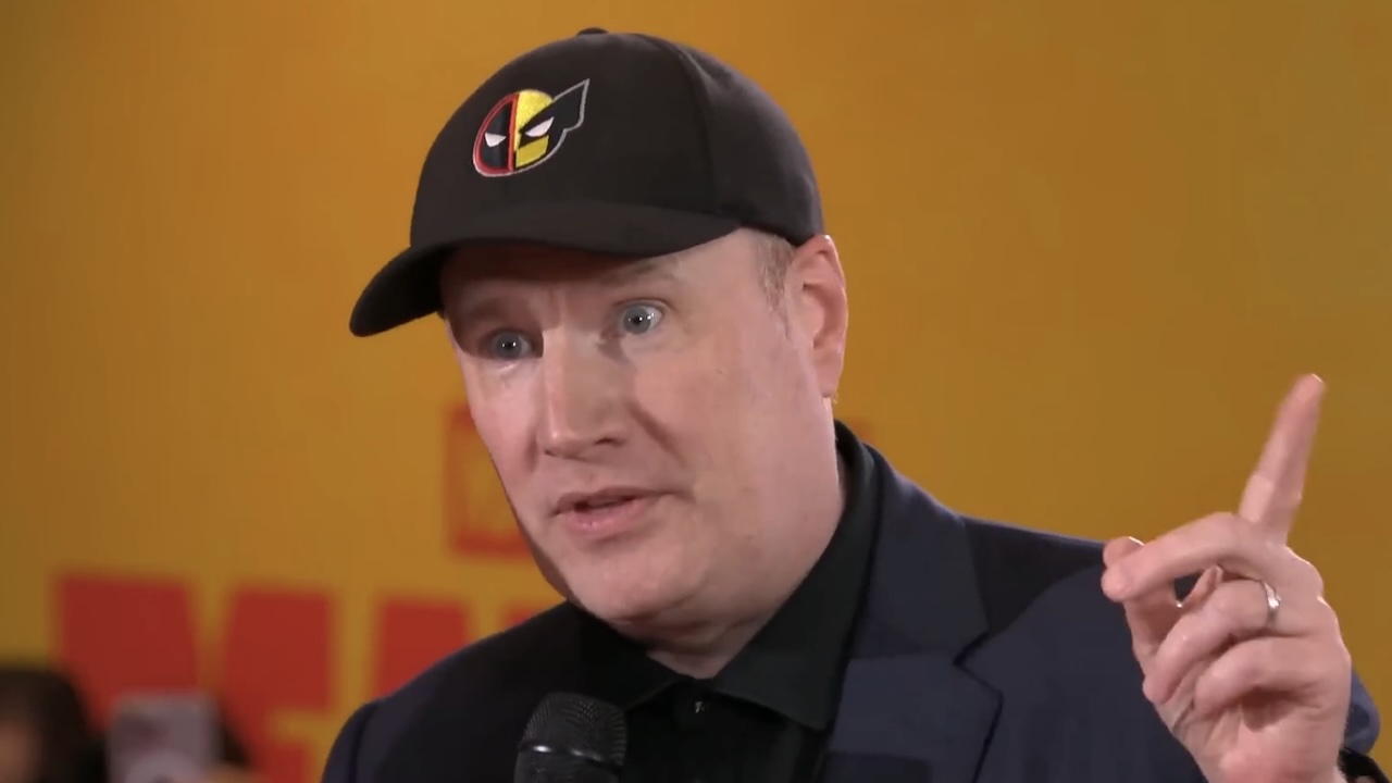 Kevin Feige wearing Deadpool and Wolverine hat and pointing upwards during interview