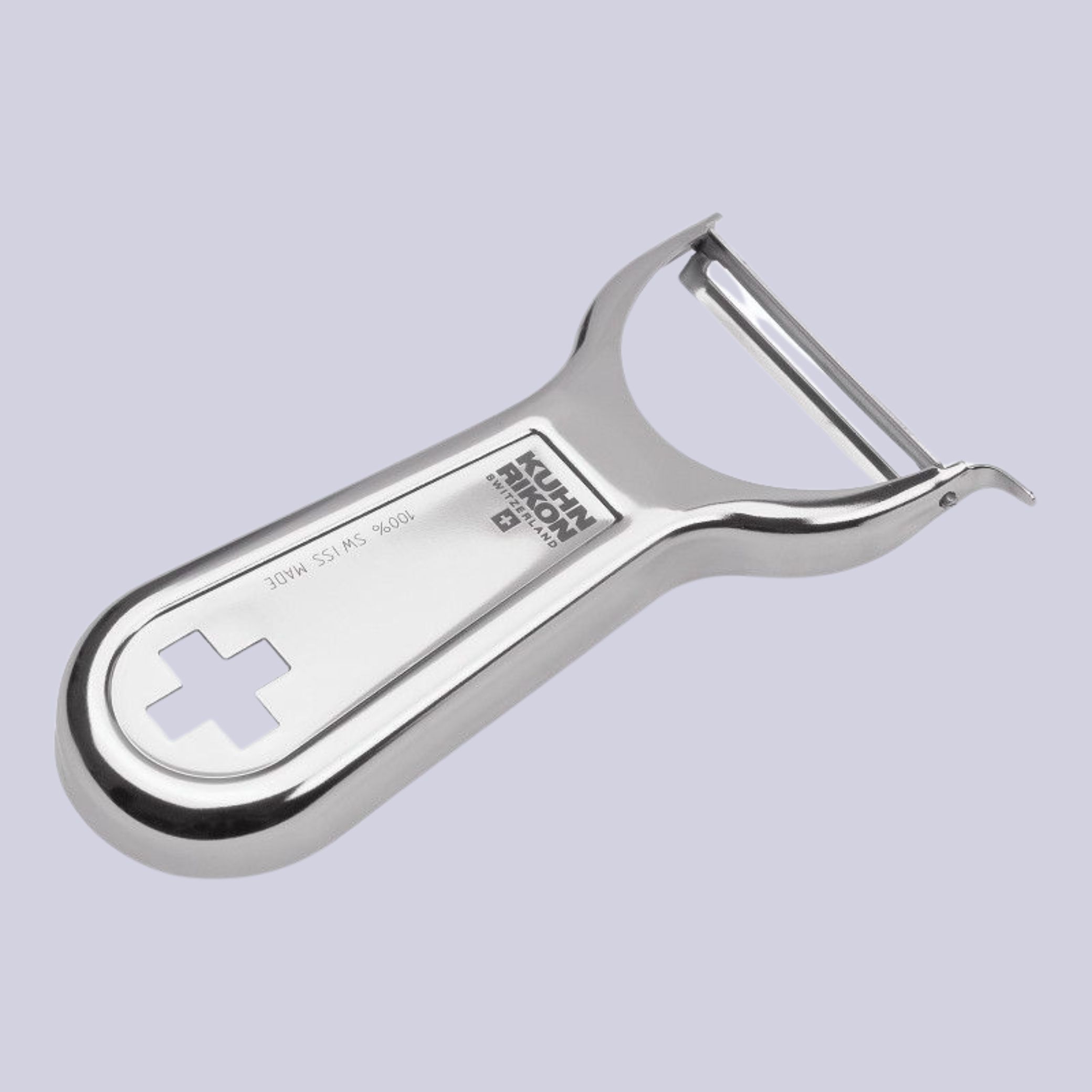 A chrome peeler with the logo KUHN RIKON and a swiss cross sat against a pale lilac background.