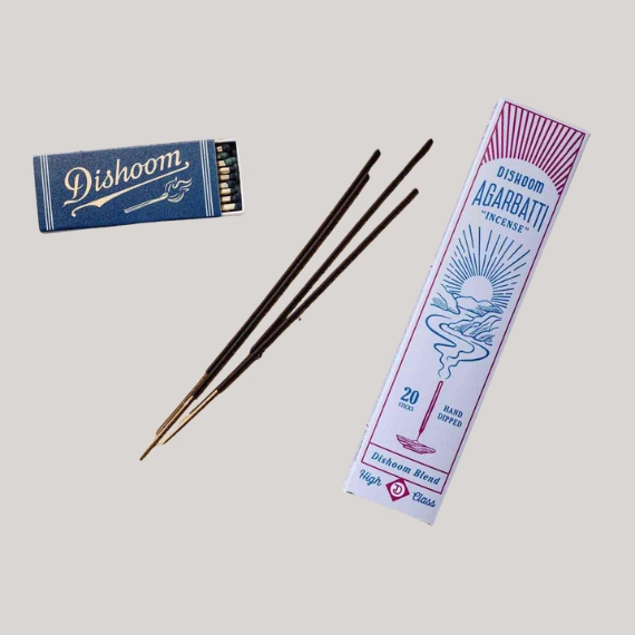 Dishoom incense box in blue, white, and red, sitting against a pale grey background.