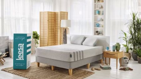 A Leesa Mattress on a bed in a bedroom next to a Leesa delivery box.