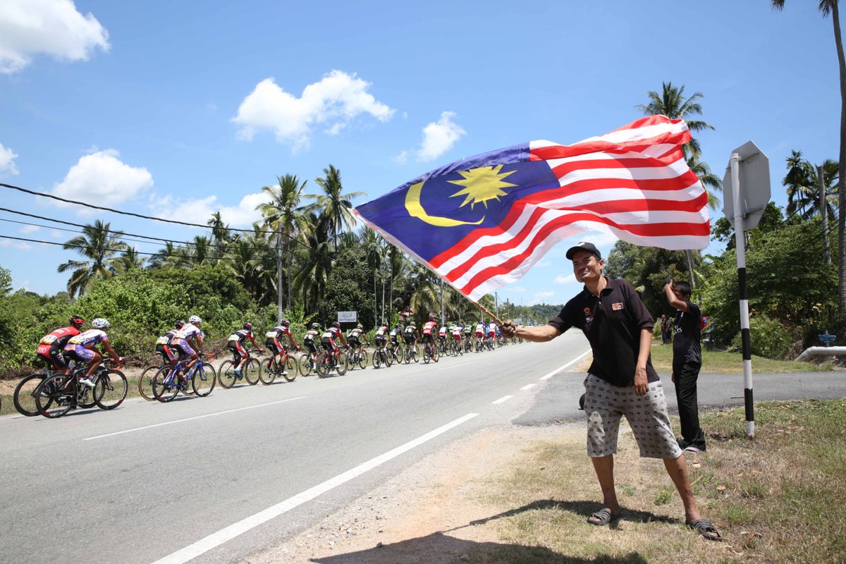 A Malaysian fan cheers on the peloton