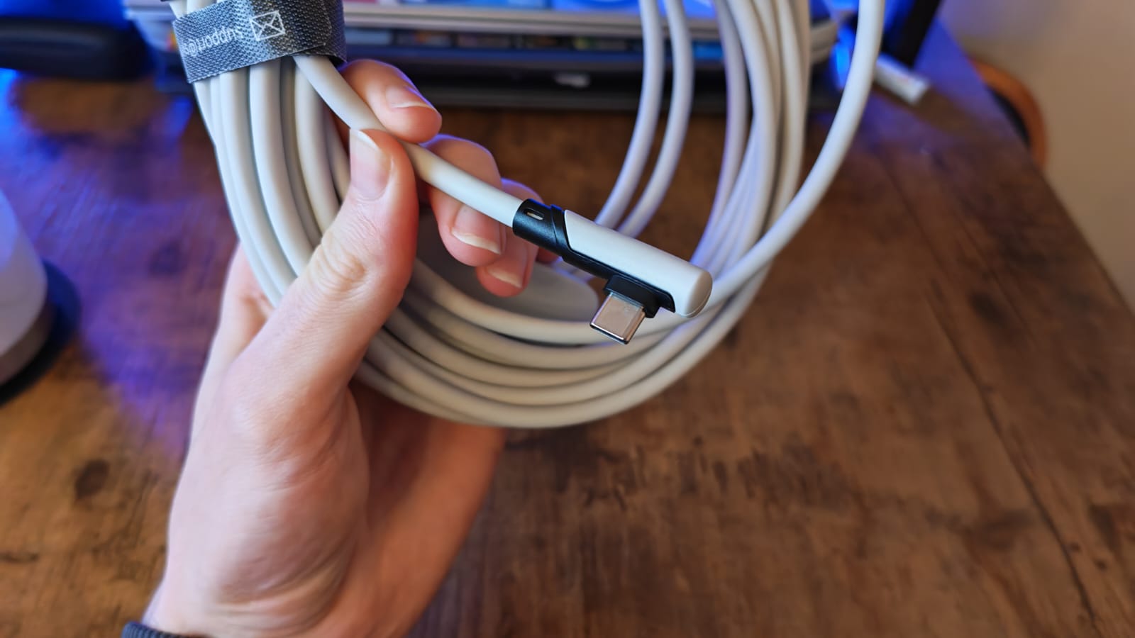 A reviewer showing the right-angled side of the Syntech Link Cable 