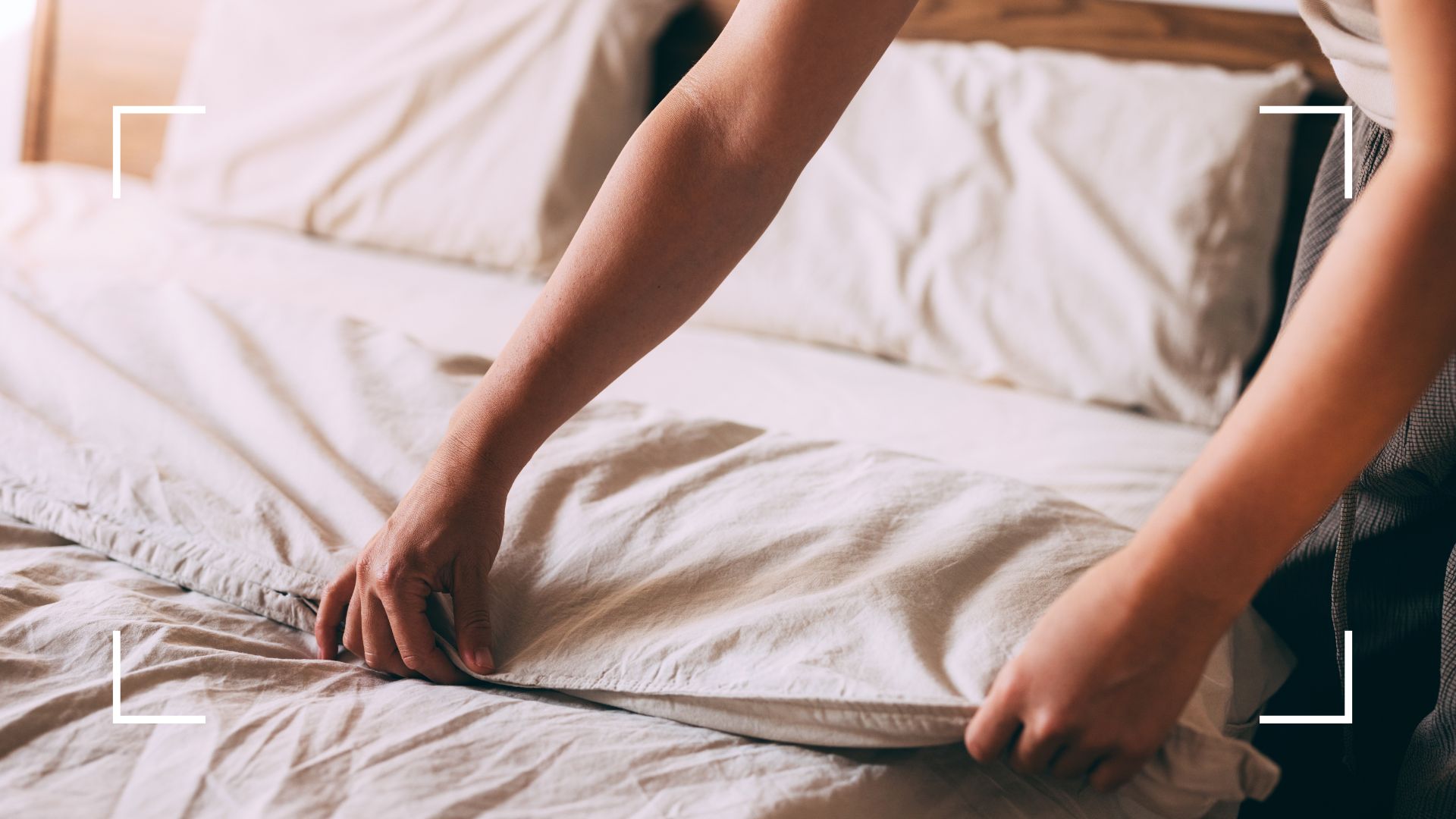 picture of woman making bed with linen sheets