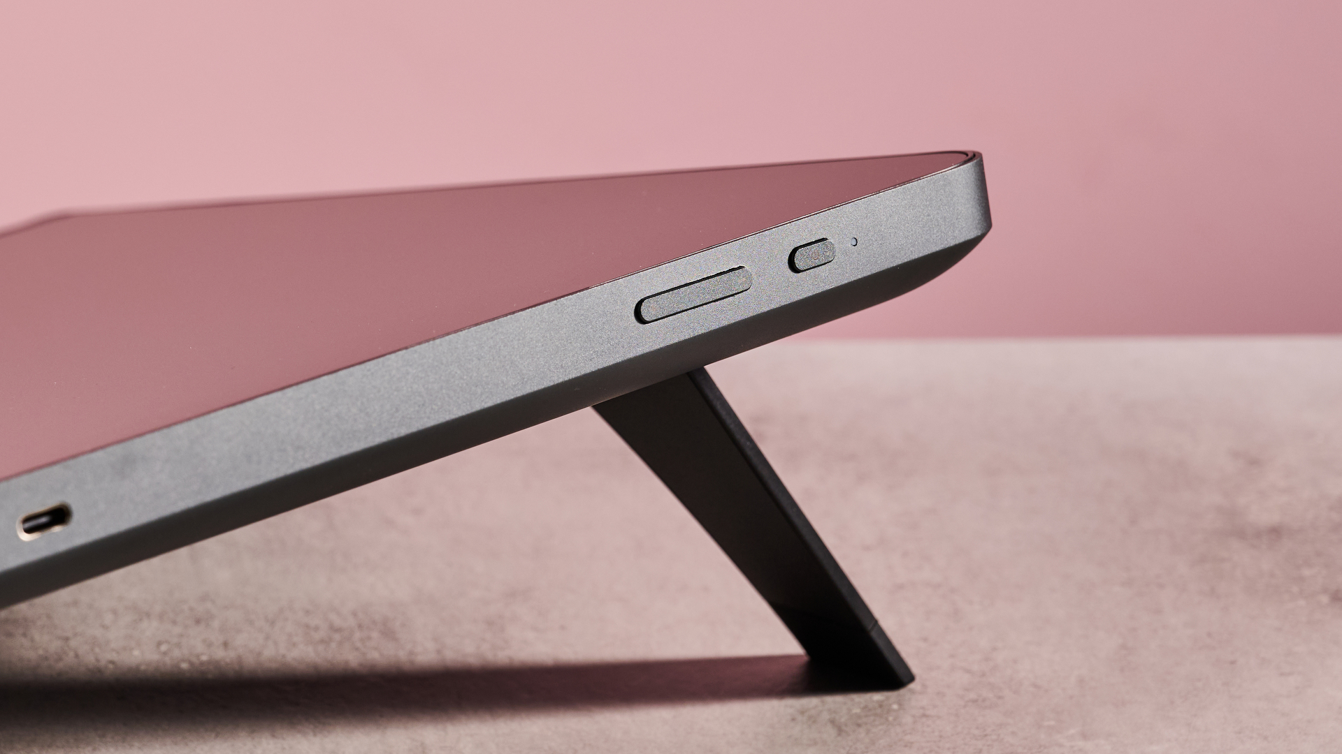 A closeup of the buttons on the top edge of the XPPen Artist Pro 19 Gen 2 in front of a pink background.