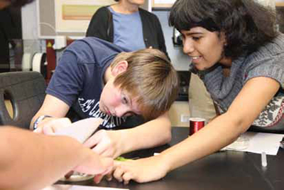 Students building a speaker out of laser-cut and 3D-printed components.