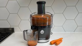 Nutribullet Juicer on a kitchen countertop with carrots that have been juiced
