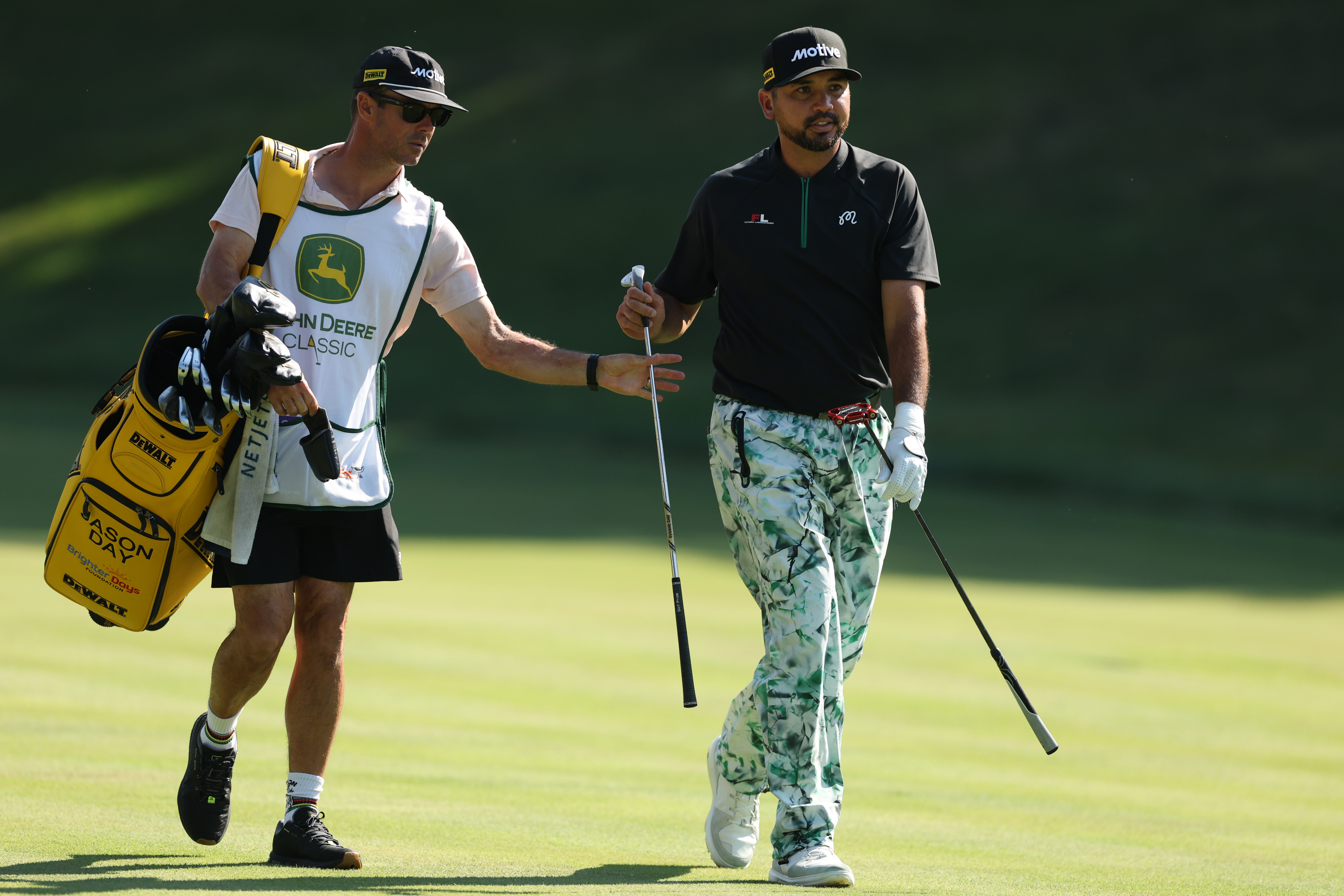 Jason Day and his caddie walk down the fairway
