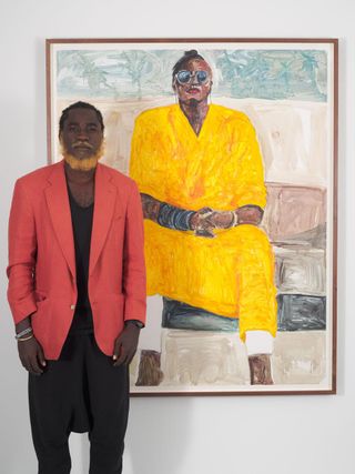 Serge Attukwei Clottey stands in front of one of his works in the exhibition 'Beyond Skin' at Simchowitz Gallery, Los Angeles