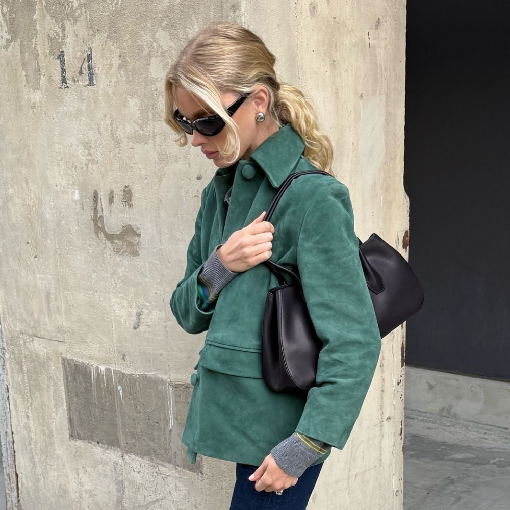Model Elsa Hosk wears a dark green suede jacket with straight-leg jeans and heeled ballet pumps.