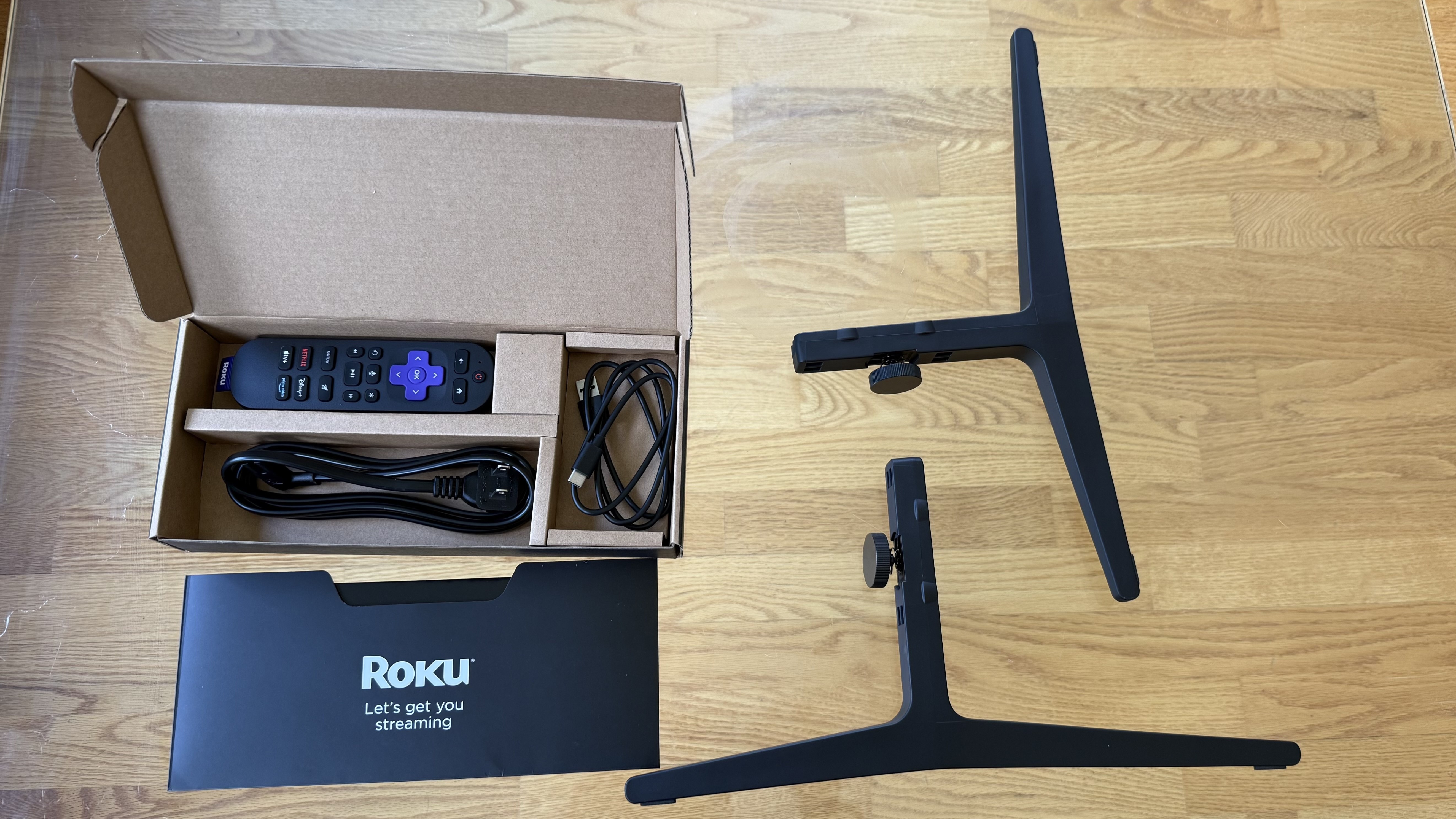 Roku Pro Series TV (2025) accessories on wood floor