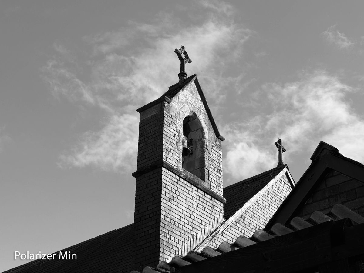A monochrome photo of a church bell tower taken on an iPhone 15 Pro using the Sandmarc polarizing filter
