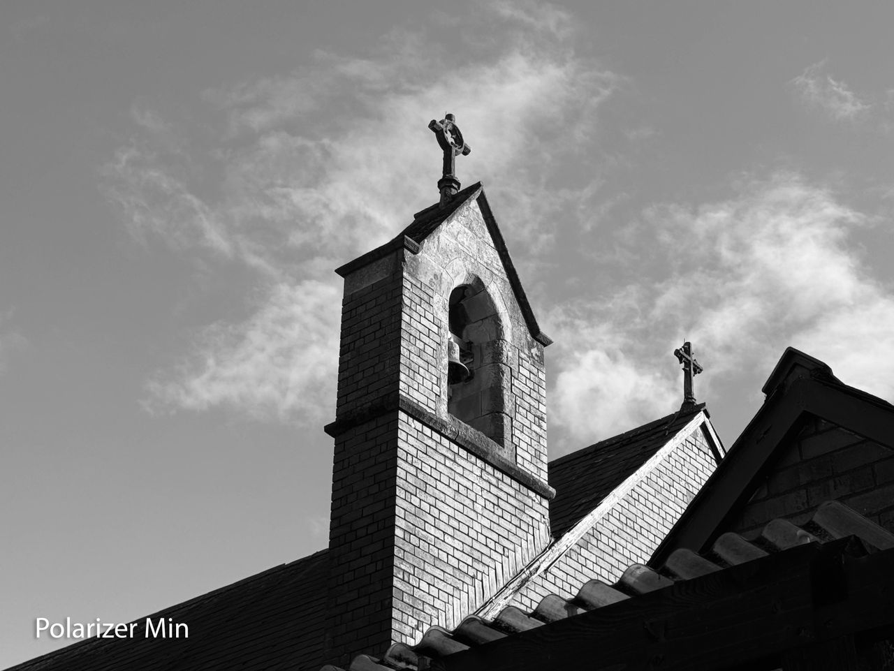 A monochrome photo of a church bell tower taken on an iPhone 15 Pro using the Sandmarc polarizing filter