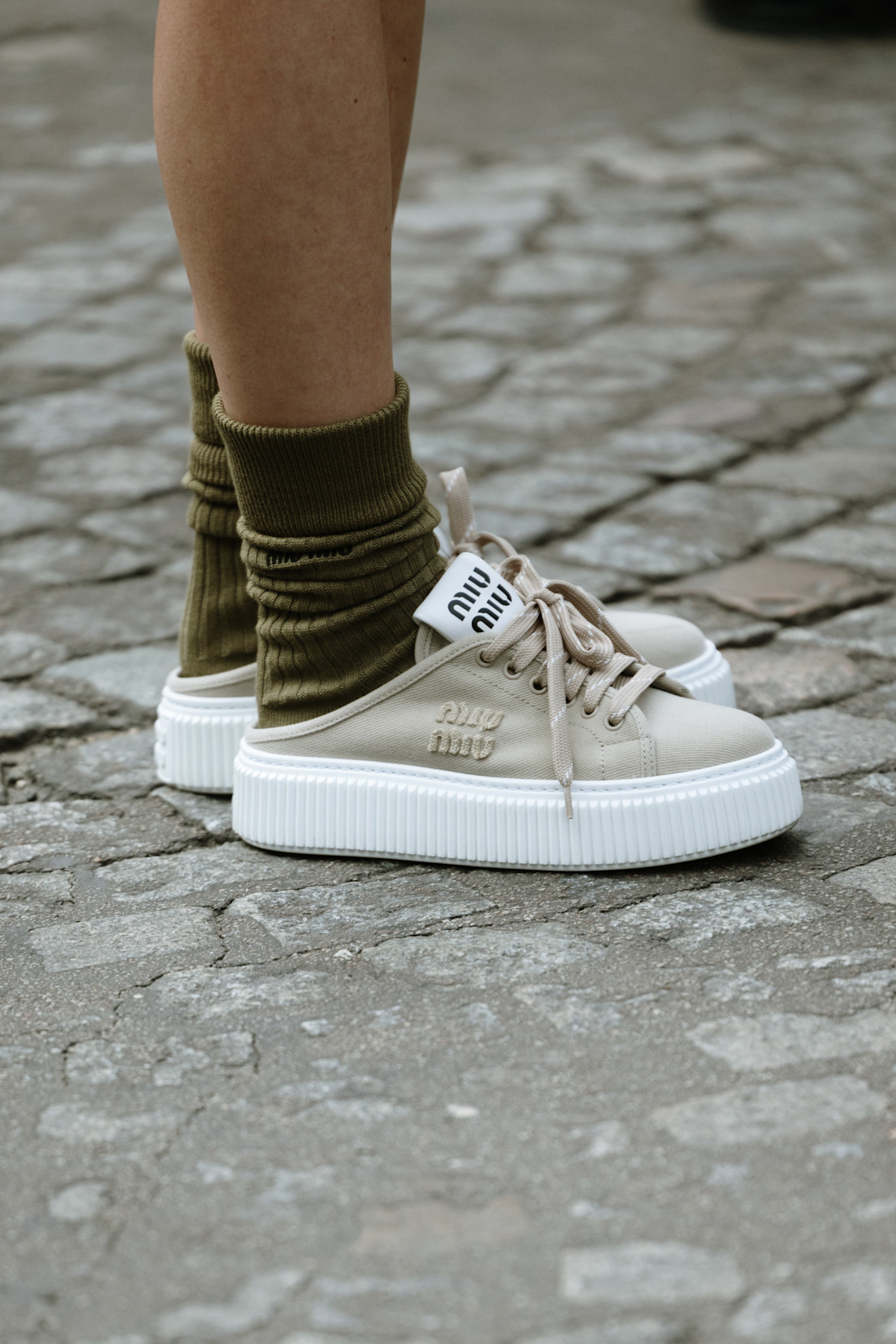Woman wearing Miu Miu sneaker wedges