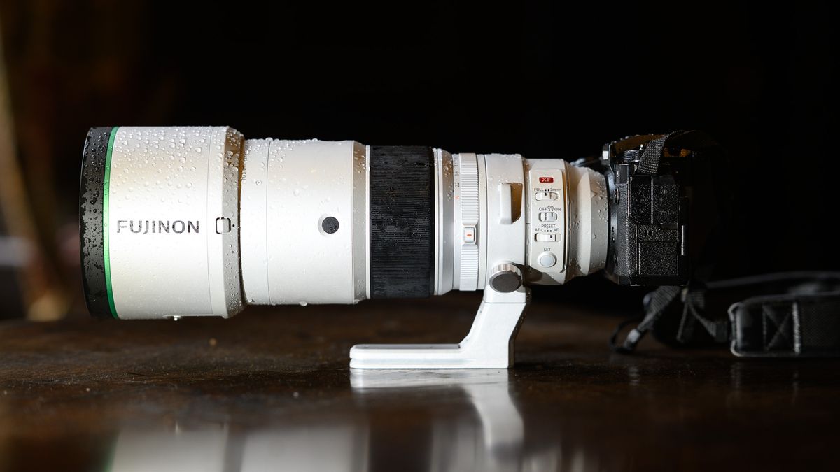 The Fujifilm XF 400mm F4.5 R LM OIS WR telephoto prime lens attached to a Fujifilm X-H2S camera, on a wooden table