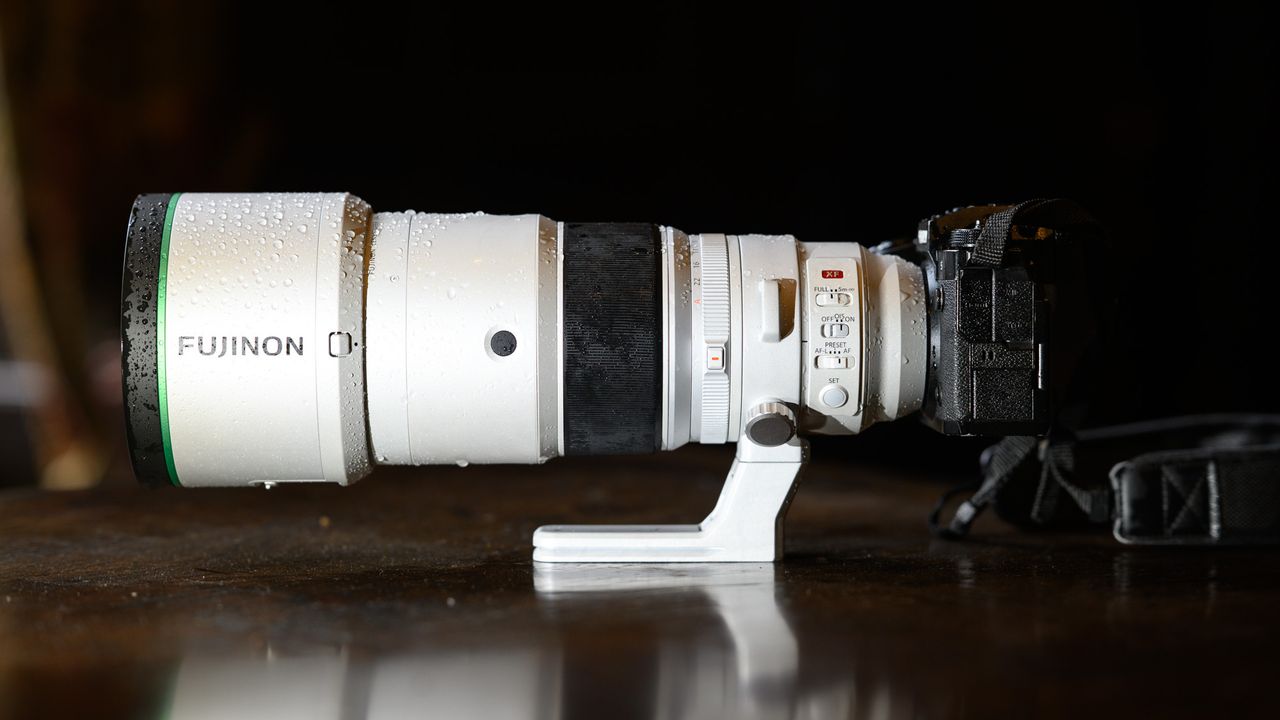 The Fujifilm XF 400mm F4.5 R LM OIS WR telephoto prime lens attached to a Fujifilm X-H2S camera, on a wooden table