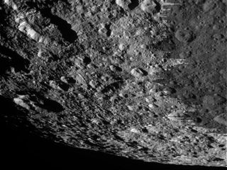 A closeup view of the Saturn moon Rhea's cratered surface.