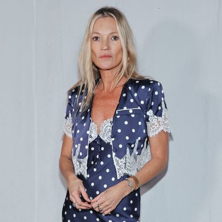Kate Moss wears a midi-length polka dot dress with heeled lace-up boots.