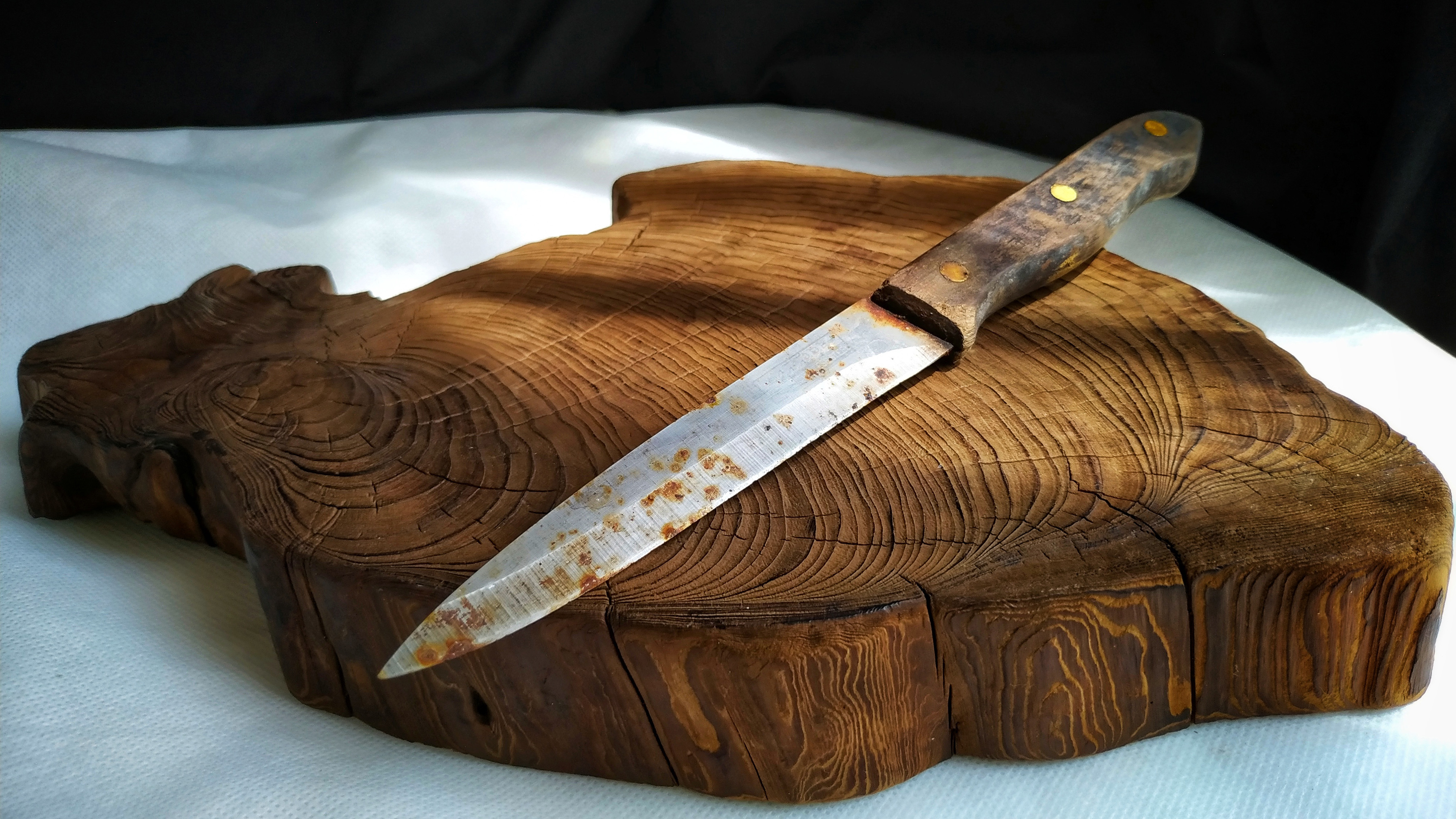 Ржавый нож на деревянной разделочной доске