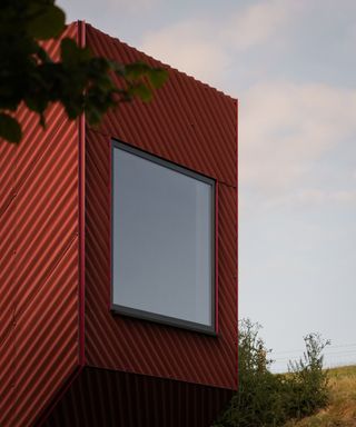 Exterior shot of a small red cabin house