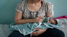 A woman holds an oxygen mask over the face of a baby with Covid-19 in a children's hospital in Kiev.