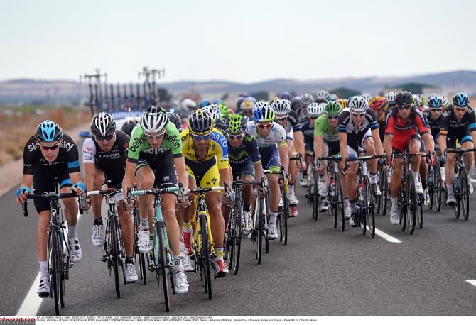 The peloton moves to the edge of the road in strong crosswinds
