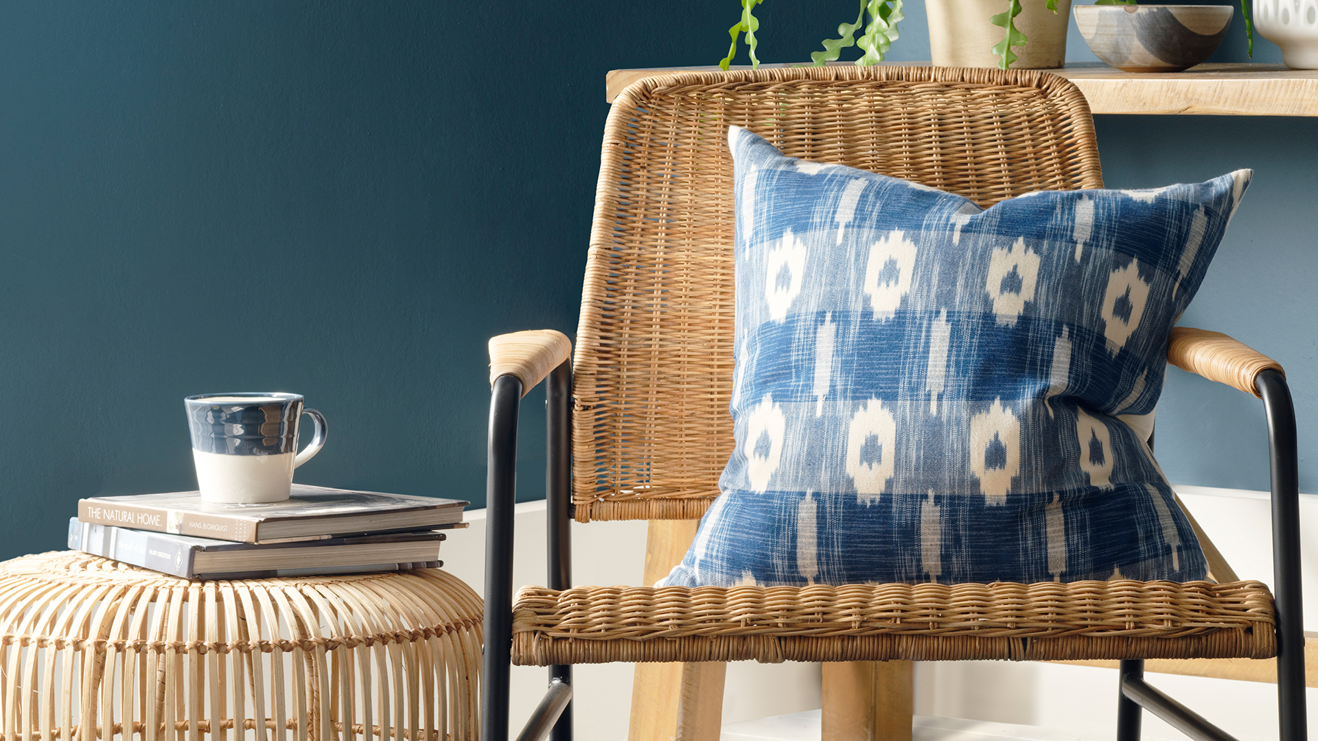 dark blue living room with a rattan chair and wicker coffee table
