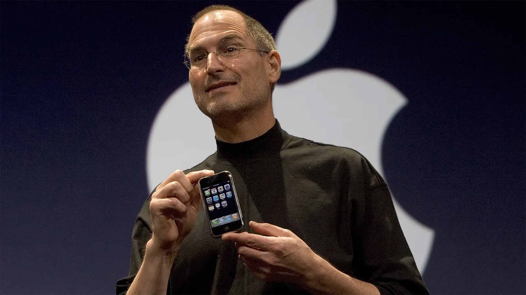 Steve Jobs segurando o iPhone original no anúncio ainda em 2007