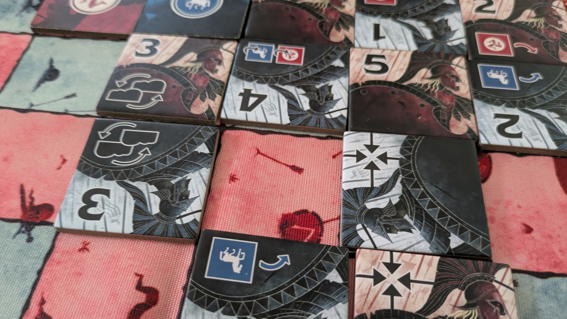 Iliad tile pieces laid out on a multi-color grid