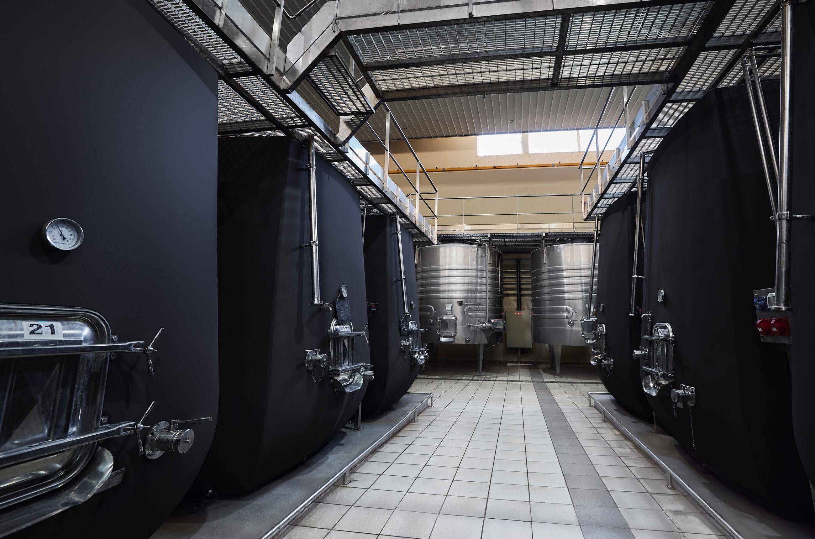 Room with large black and stainless steel vats