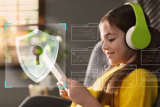 Little girl wearing green overear headphones using tablet at home