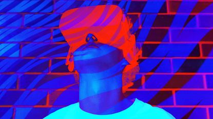 Young person looking through red VR headset at brick wall with blue wavy lines