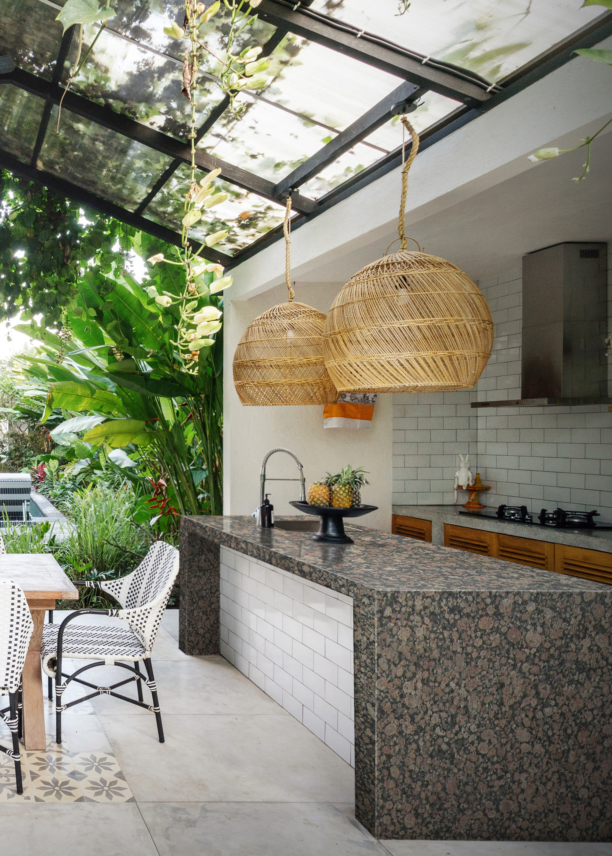 outdoor kitchen and dining area with slanted glass roof
