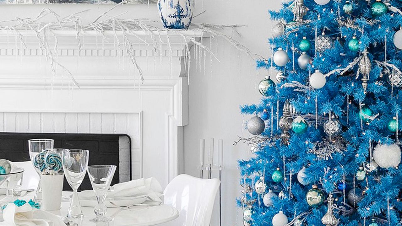 A bright blue Christmas tree in a white living room