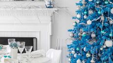 A bright blue Christmas tree in a white living room