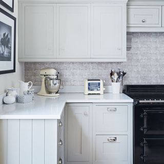 Corner of the kitchen in a Georgian house in Cheltenham decorated in pale grey with a dark blue Aga