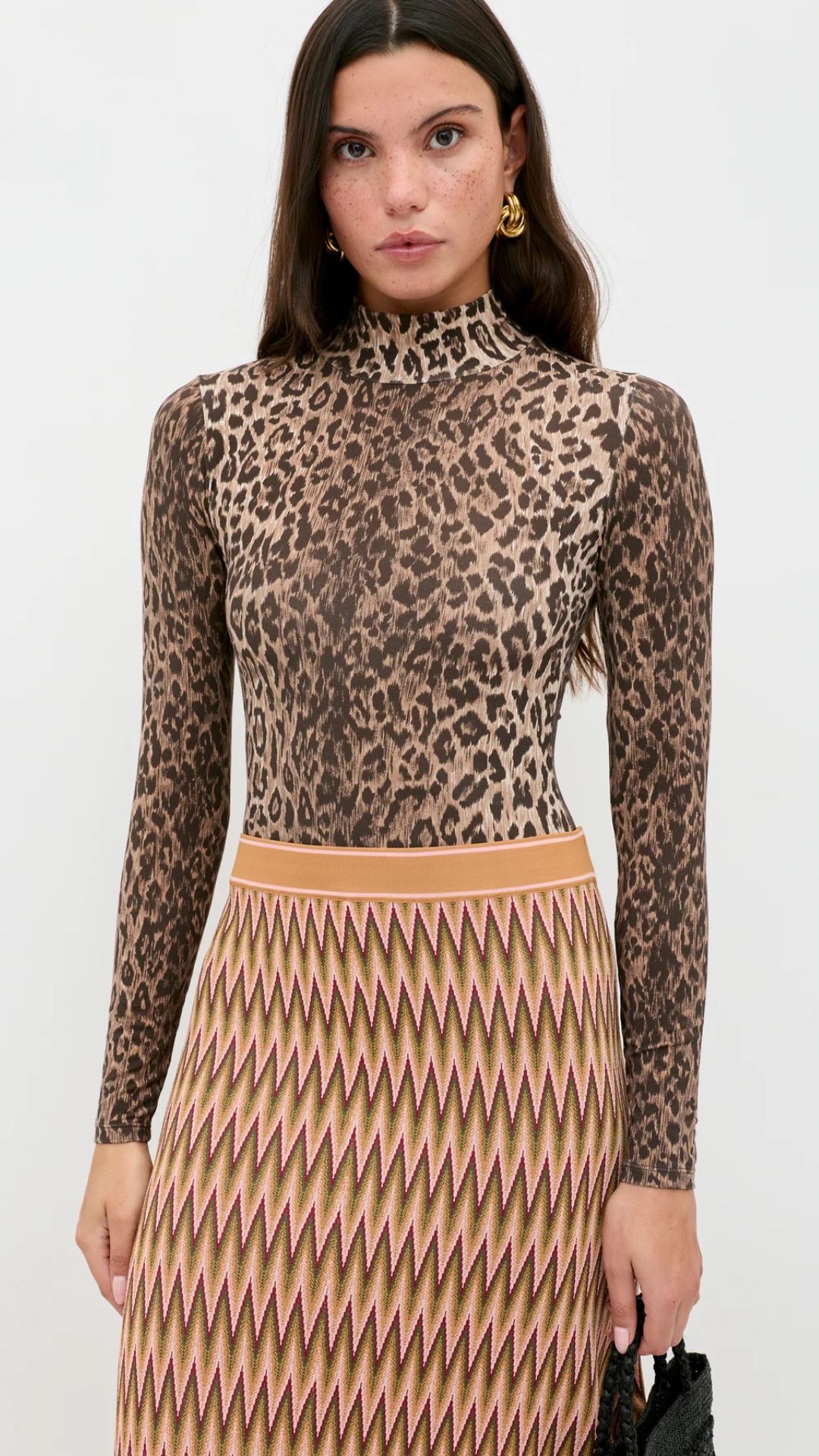 A MODEL WEARING A LEOPARD PRINT ONE PIECE WITH A PATTERNED SKIRT