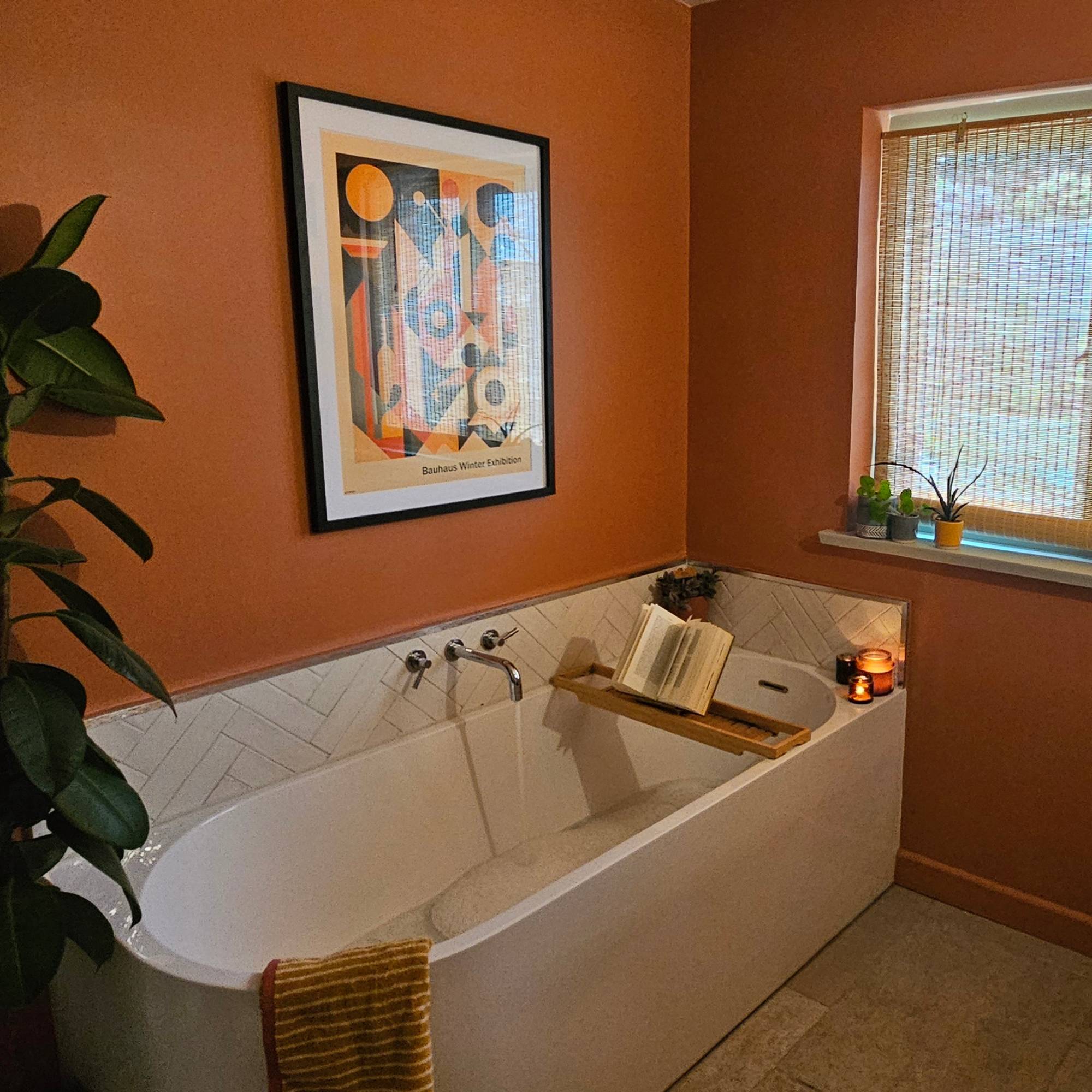 dark red bathroom with running bath and candles