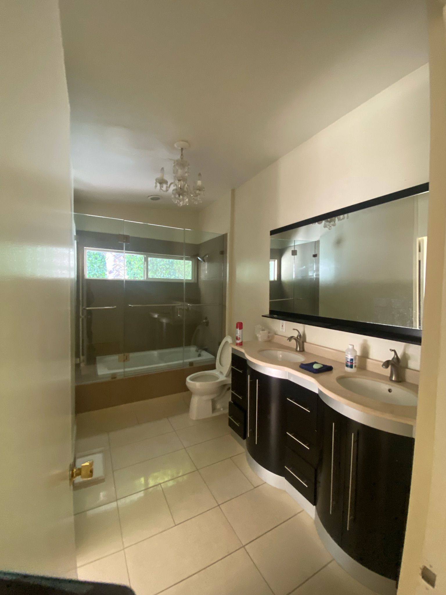 A dated monochrome bathroom with a double vanity