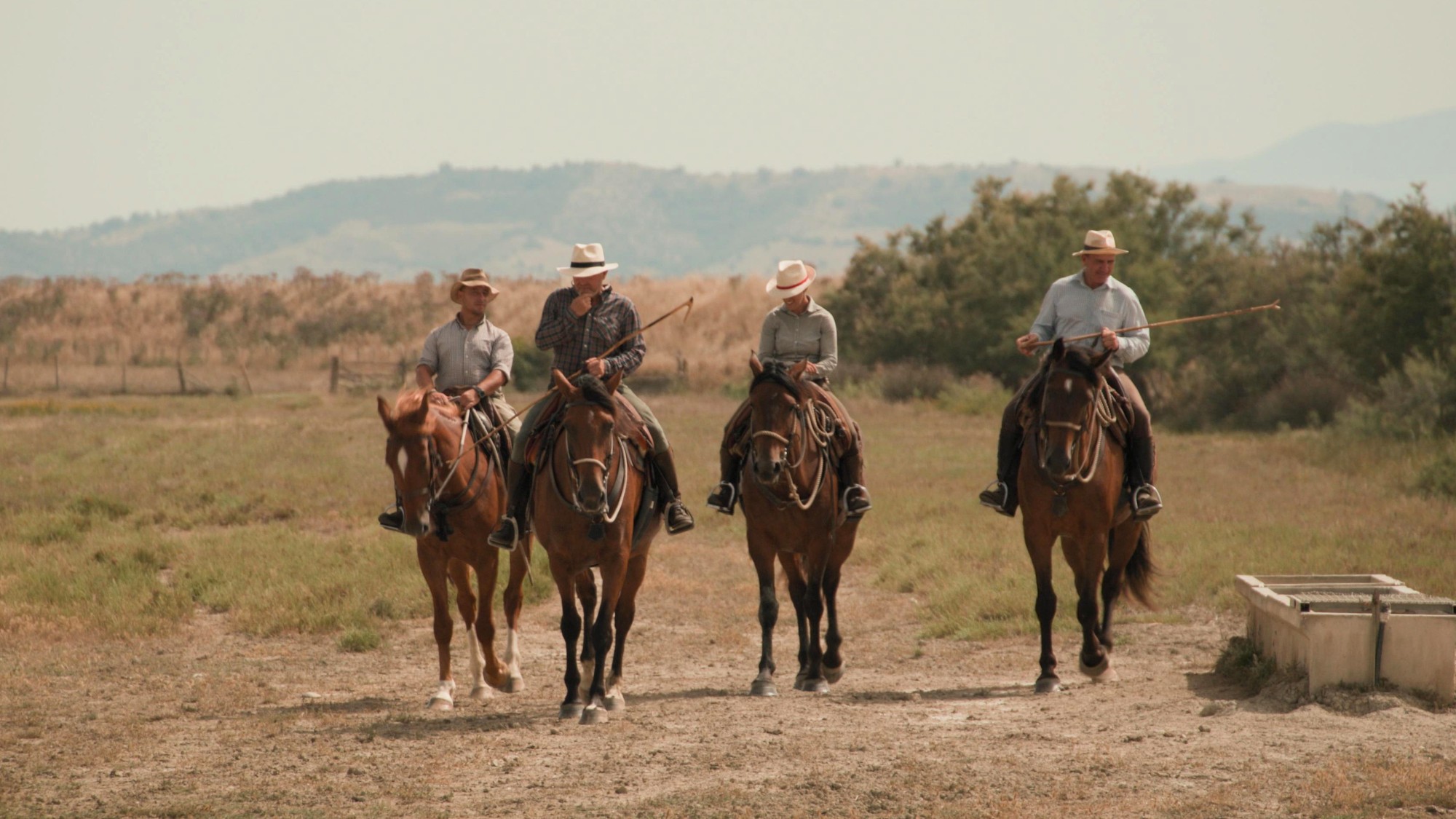 Butteri Stefano Pavin, Luca Bettiol, Luca De Santis, and Sara Nuti ride their horses across the Alberese farm in Tuscany in Tucci in Italy