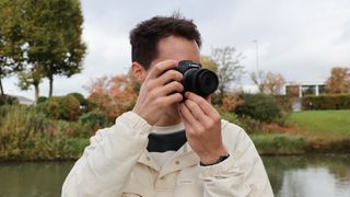 A Canon RF-S 10-18mm f/4.5-6.3 IS STM lens on a Canon EOS R5 camera held up to a man's face