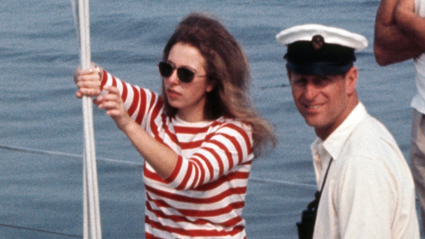 Princess Anne holds onto a pole aboard a boat in 1970