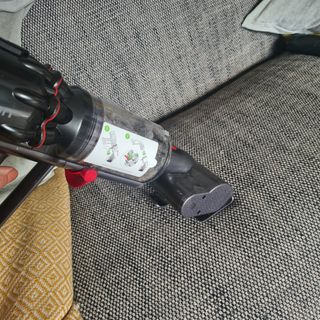 Dyson Micro 1.5kg motorised brush being used on a sofa