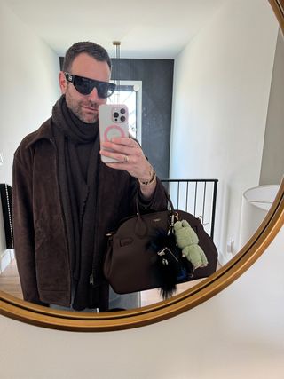 Bobby Schuessler wearing a Banana Republic jacket, Brochu Walker scarf, and Coach Empire Bag.