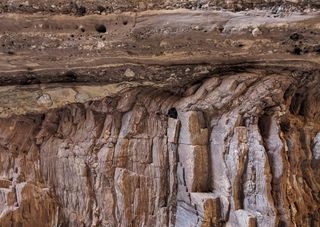 The Great Unconformity is visible where the horizontal layer filled with pebbles sits atop a vertical layer of rock within the Grand Canyon. Between these two layers, hundreds of millions of years of rock are missing