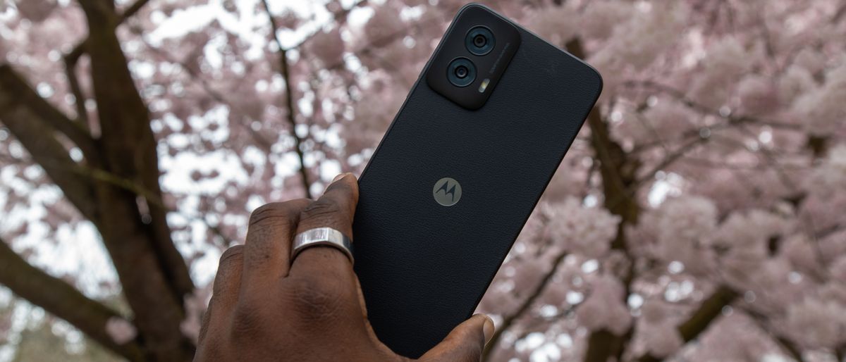 The Moto G Power 5G 2024 in hand with cherry blossoms behind