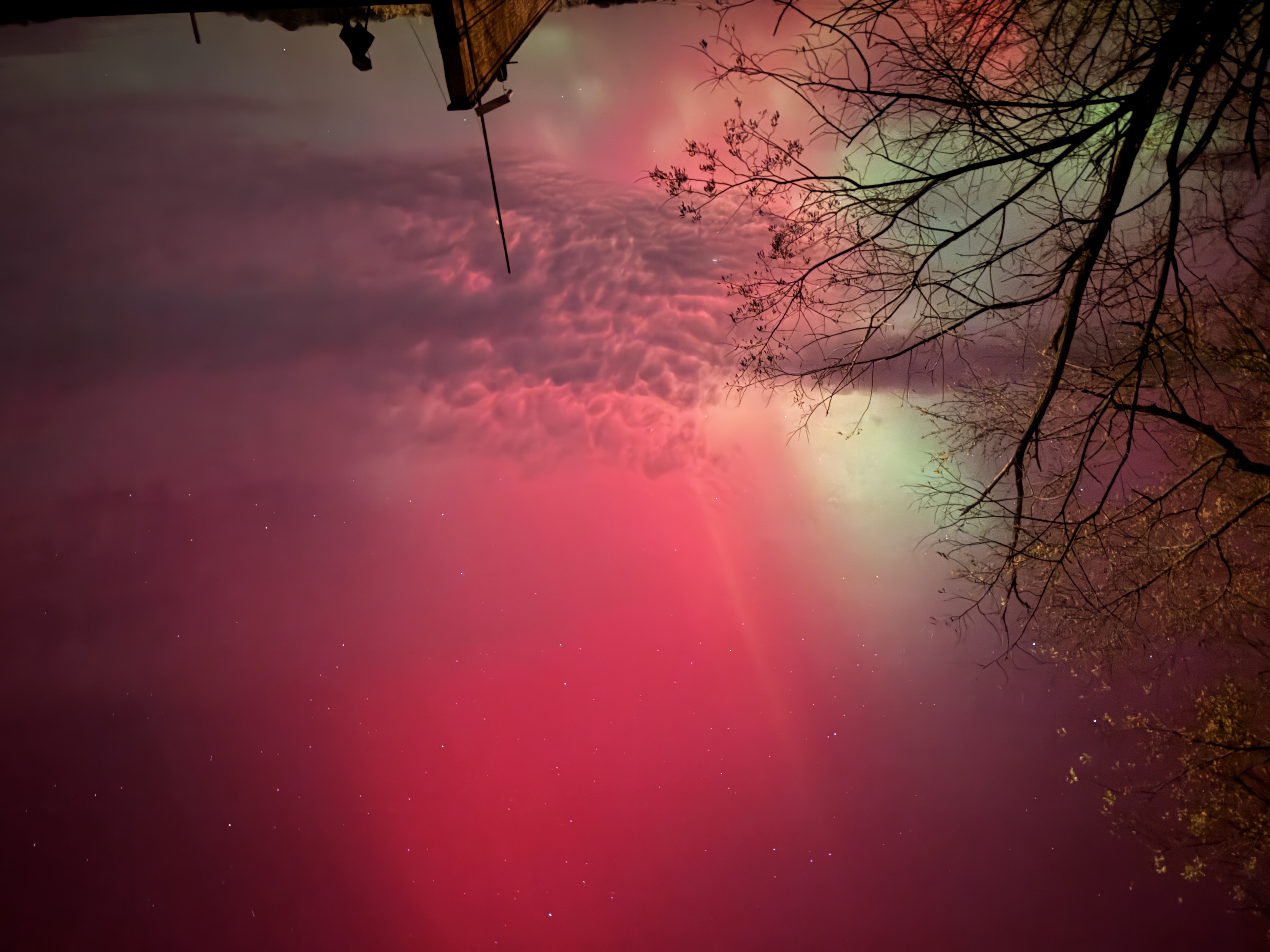 北極光在天空中呈現為紅色和綠色光幕。