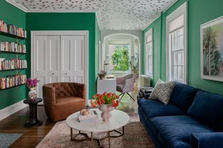 A living room with dark wood flooring and bright green walls