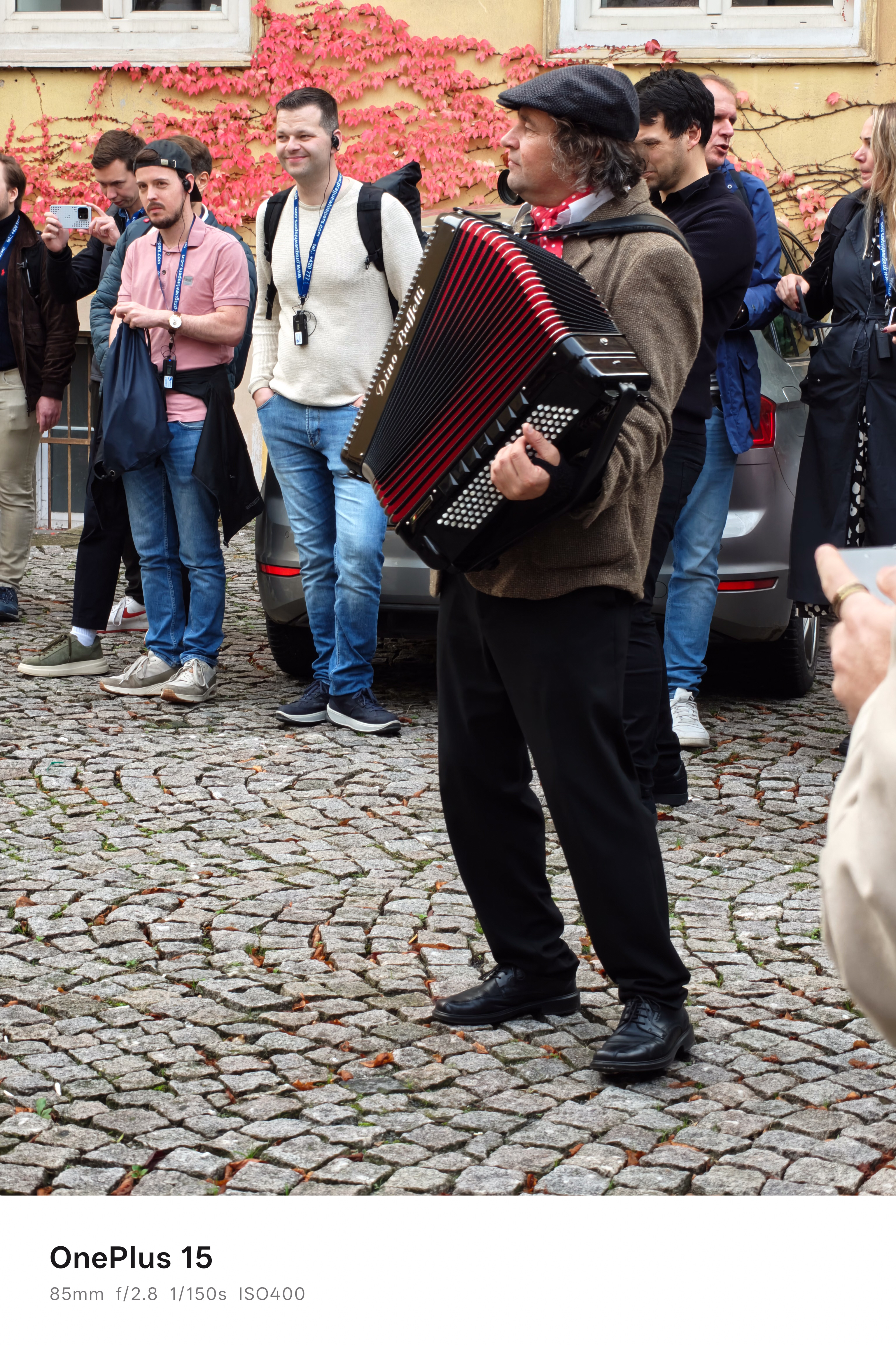 A man playing an accordion to an audience of onlookers