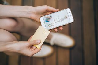 Woman holds payment card and online shops